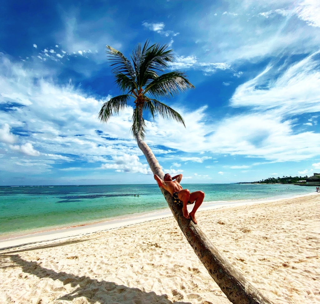 Relaxing on an iconic curved palm tree in the Dominican Republic